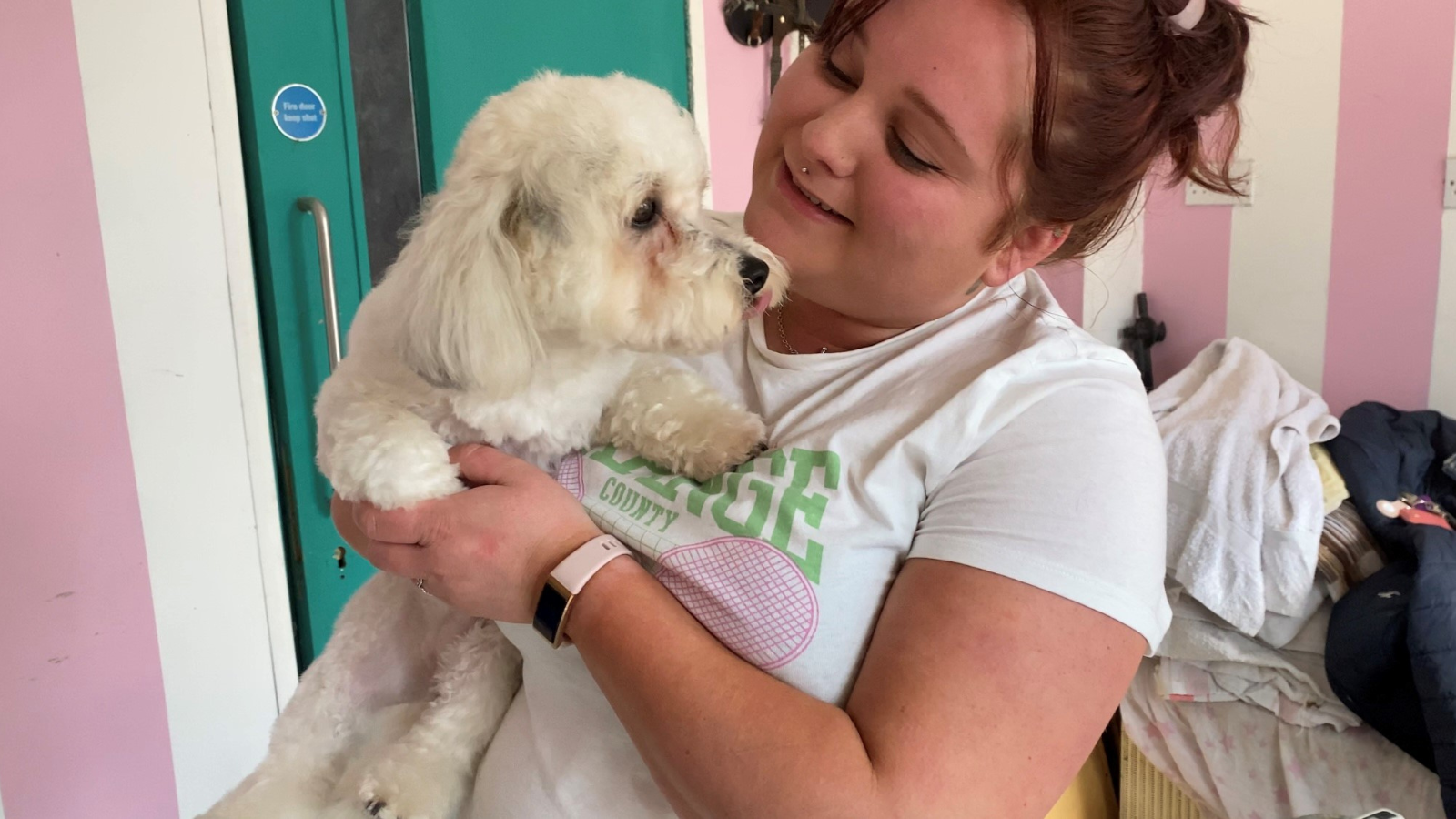 Penny the Dog being held by her dog groomer Melissa