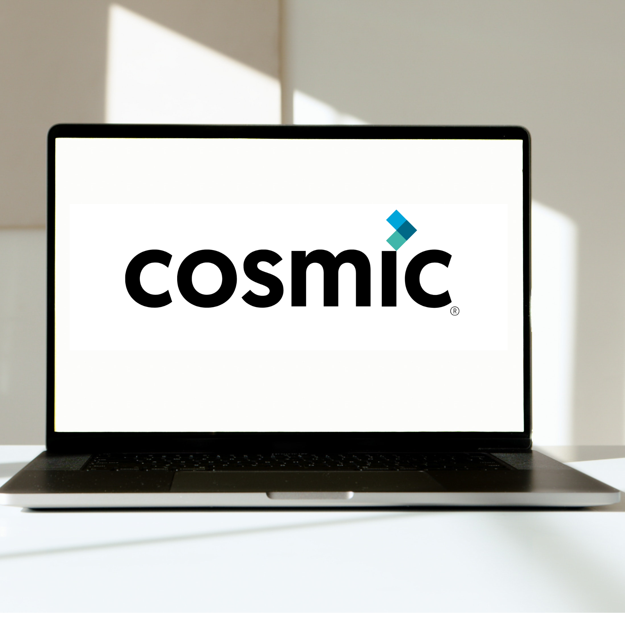 A laptop displaying the Cosmic logo